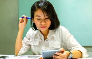 Young Woman Engrossed In Application At Table